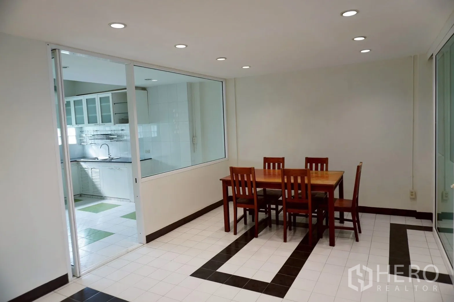 带办公室的家 for rent in Watthana, Bangkok - 靠玻璃厨房的用餐区，射灯与木质餐桌。