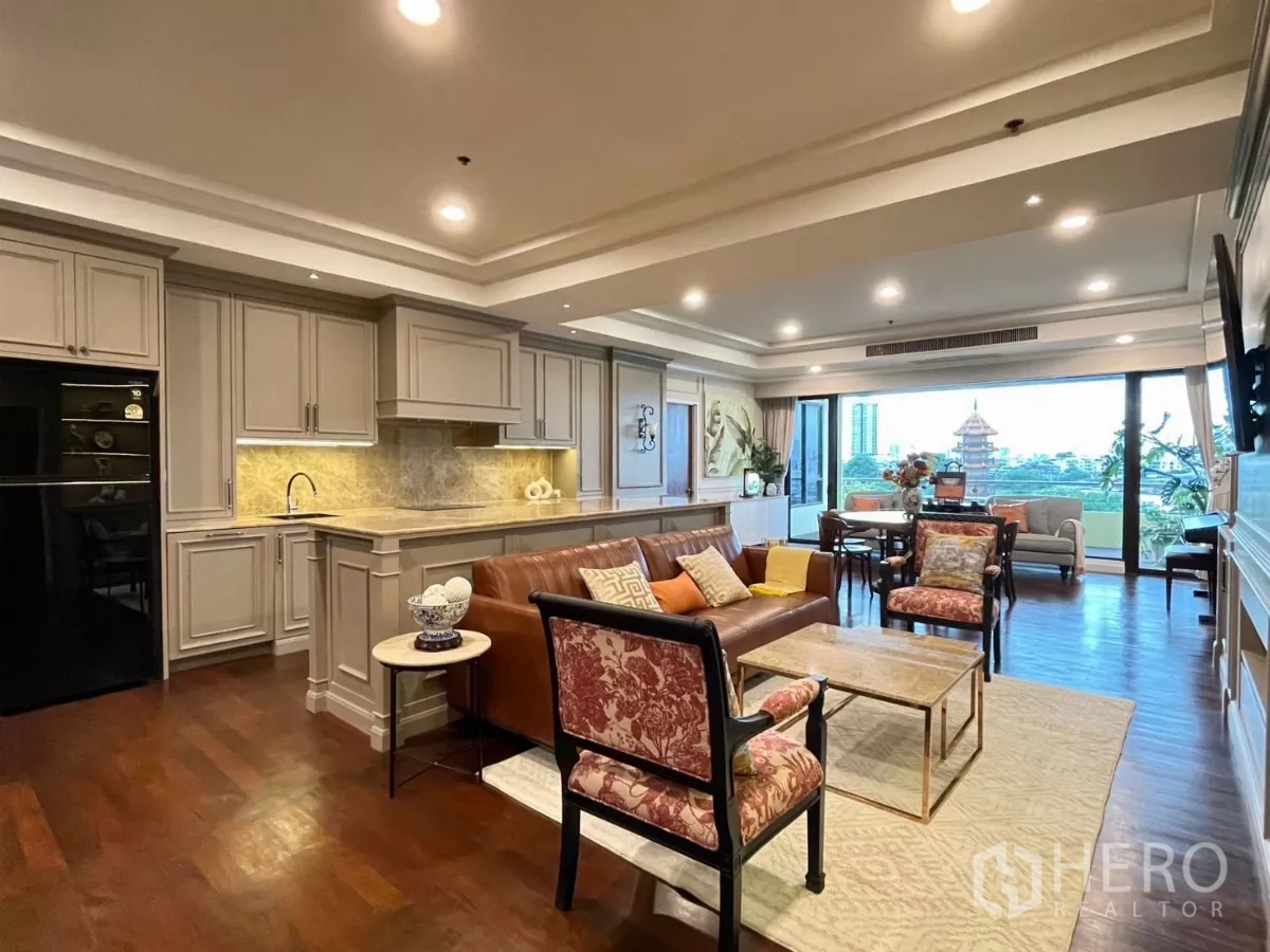 คอนโด ให้เช่าในKhlong San, Bangkok - ครัวเปิดและห้องนั่งเล่น ตู้บิวท์อินคลาสสิก โซฟาหนัง มองเห็นเมืองและเจดีย์ผ่านหน้าต่างบานใหญ่
