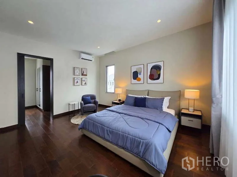 บ้าน ให้เช่าหรือขายในLat Krabang, Bangkok - ห้องนอนผ้าปูสีน้ำเงิน เก้าอี้มุมอ่านหนังสือ และตู้เสื้อผ้าต่อเนื่อง