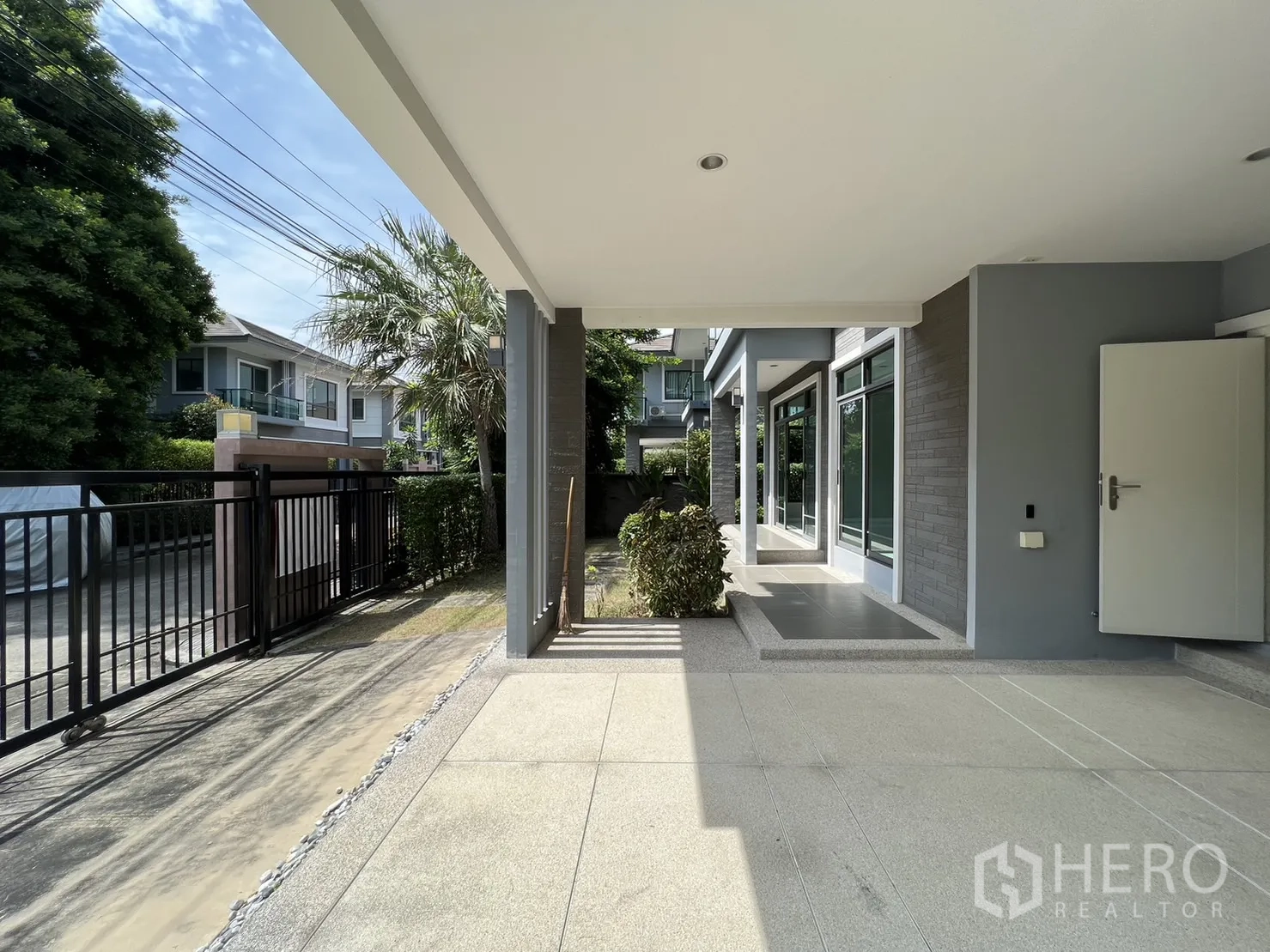 Detached House for sale in Suan Luang, Bangkok - View from carport to front gate and glass-lined façade.