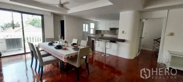 ทาวน์เฮาส์ ให้เช่าในSathon, Bangkok - พื้นที่รับประทานอาหารสว่าง โต๊ะหกที่นั่ง เคาน์เตอร์บาร์ และประตูกระจกบานเลื่อนไปยังระเบียง