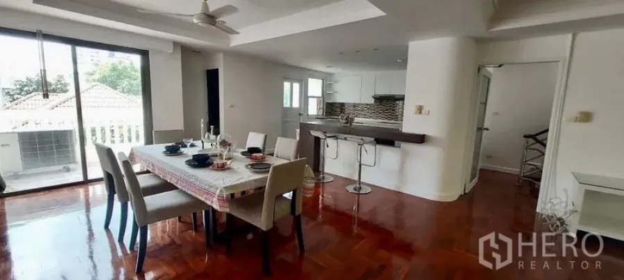 ทาวน์เฮาส์ ให้เช่าในSathon, Bangkok - พื้นที่รับประทานอาหารสว่าง โต๊ะหกที่นั่ง เคาน์เตอร์บาร์ และประตูกระจกบานเลื่อนไปยังระเบียง