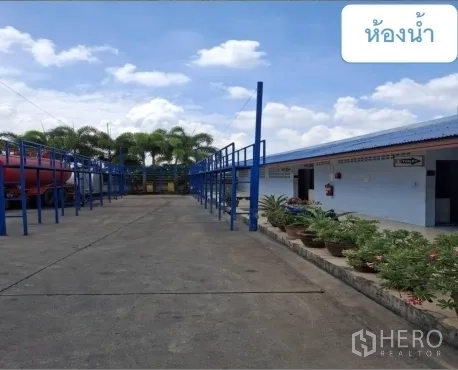 货栈 出租在Mueang Pathum Thani, Pathum Thani - 室外通道通往洗手间建筑，旁为堆场