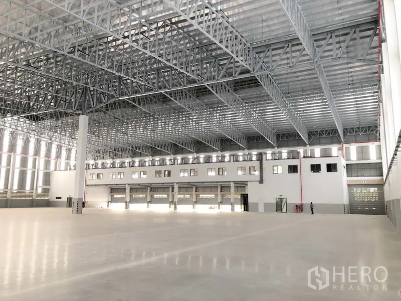 工厂 出租或出售在Samut Prakan - 仓库大厅，设装卸门、夹层式办公室窗及安全标识。
