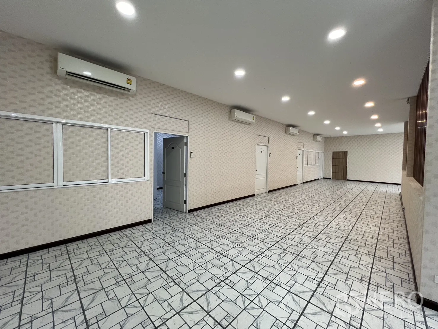 零售空间 for rent in Bueng Kum, Bangkok - 室内走廊区域，数个白色房门、分体空调与纹理墙面。