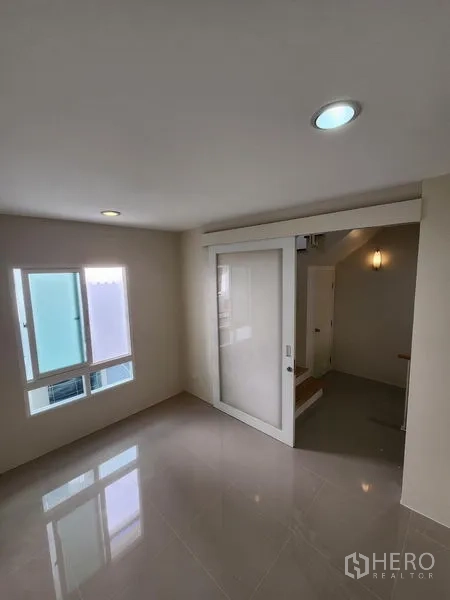 Townhouse for rent in Wang Thonglang, Bangkok - Upper landing room with sliding glass partition and a window for natural light.