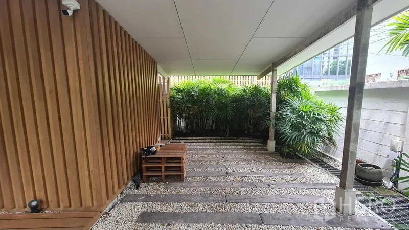 บ้าน ให้เช่าในWatthana, Bangkok - ที่จอดรถในร่มผนังไม้ระแนงและพื้นโรยกรวด