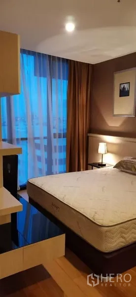 公寓 出租在Watthana, Bangkok - 黄昏时的卧室，阳台式落地窗与木地板。