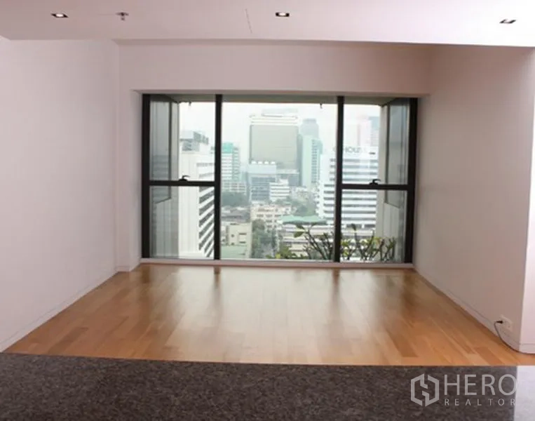 Condominium for sale in Sathon, Bangkok - Bright living area with a large picture window and Sathon skyline view in Bangkok.