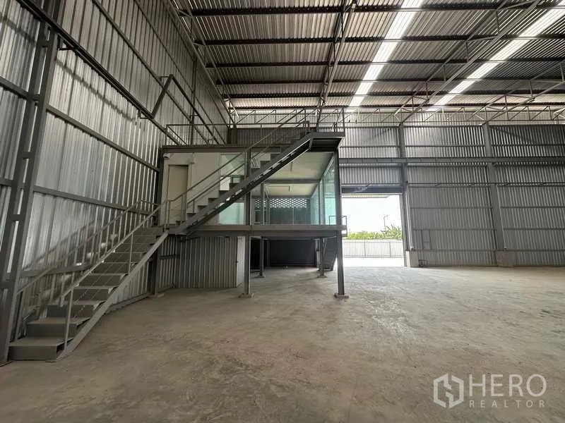 工厂 出租在Wang Noi, Phra Nakhon Si Ayutthaya - 仓库内部空间宽敞，挑高屋顶设采光带，带钢梯的夹层玻璃办公区。