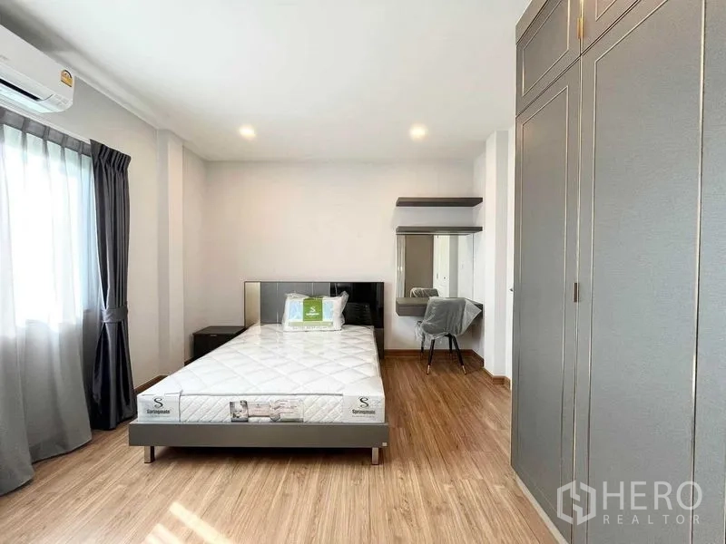Detached House for rent in Don Mueang, Bangkok - Bedroom with double bed, grey wardrobe and dressing table.