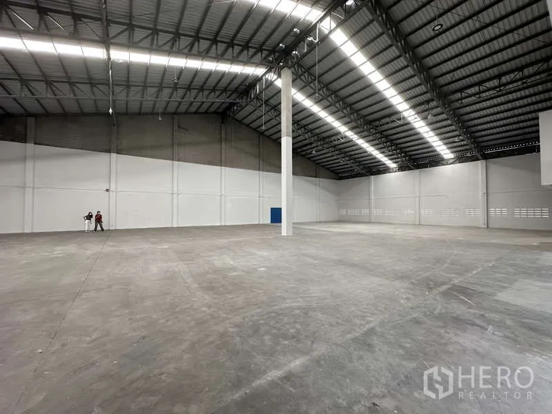 工厂 出租在Khlong Luang, Pathum Thani - 开阔生产区，混凝土地面与中央立柱，照明充足。