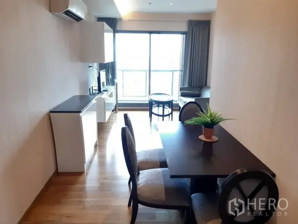 Condominium for rent in Watthana, Bangkok - Open-plan dining and living area with sliding glass doors to a bright balcony.