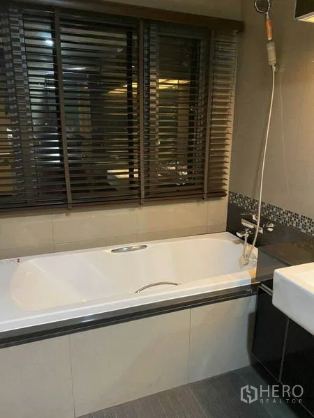 คอนโด ให้เช่าในKhlong Toei, Bangkok - ห้องน้ำมาสเตอร์ อ่างอาบน้ำใต้หน้าต่างพร้อมม่าน และฝักบัวสายอ่อน