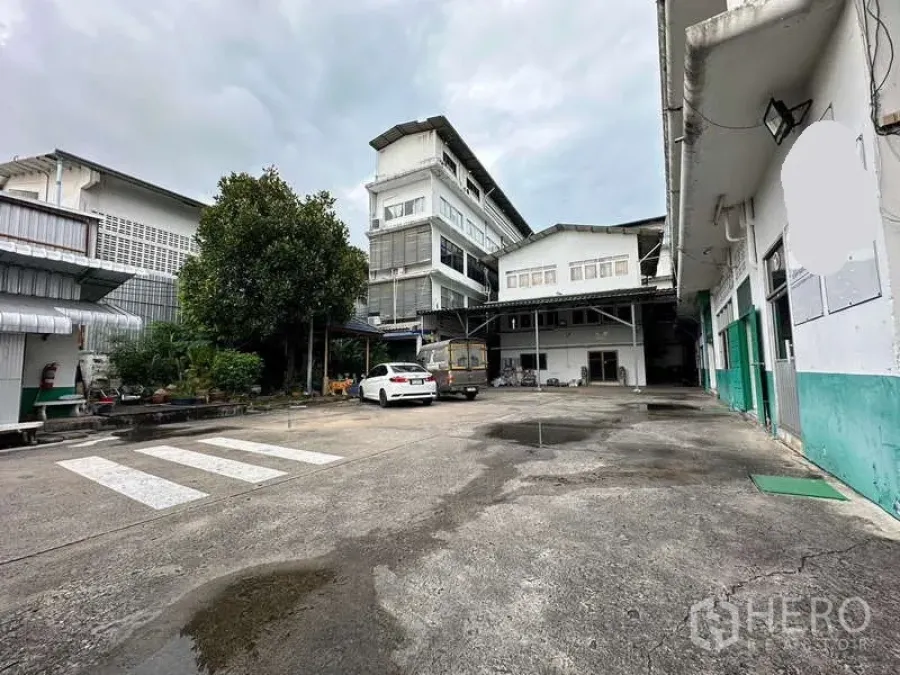 Warehouse for rent in Rat Burana, Bangkok - Spacious loading yard and parking in front of multi-level warehouse buildings.