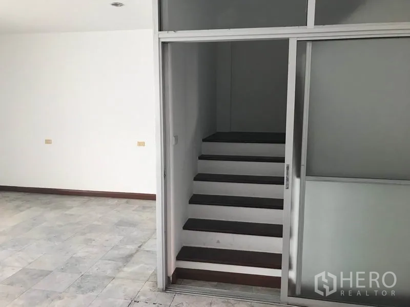 办公空间 出租在Khlong Toei, Bangkok - 办公室内的玻璃推拉隔断后方为室内楼梯。