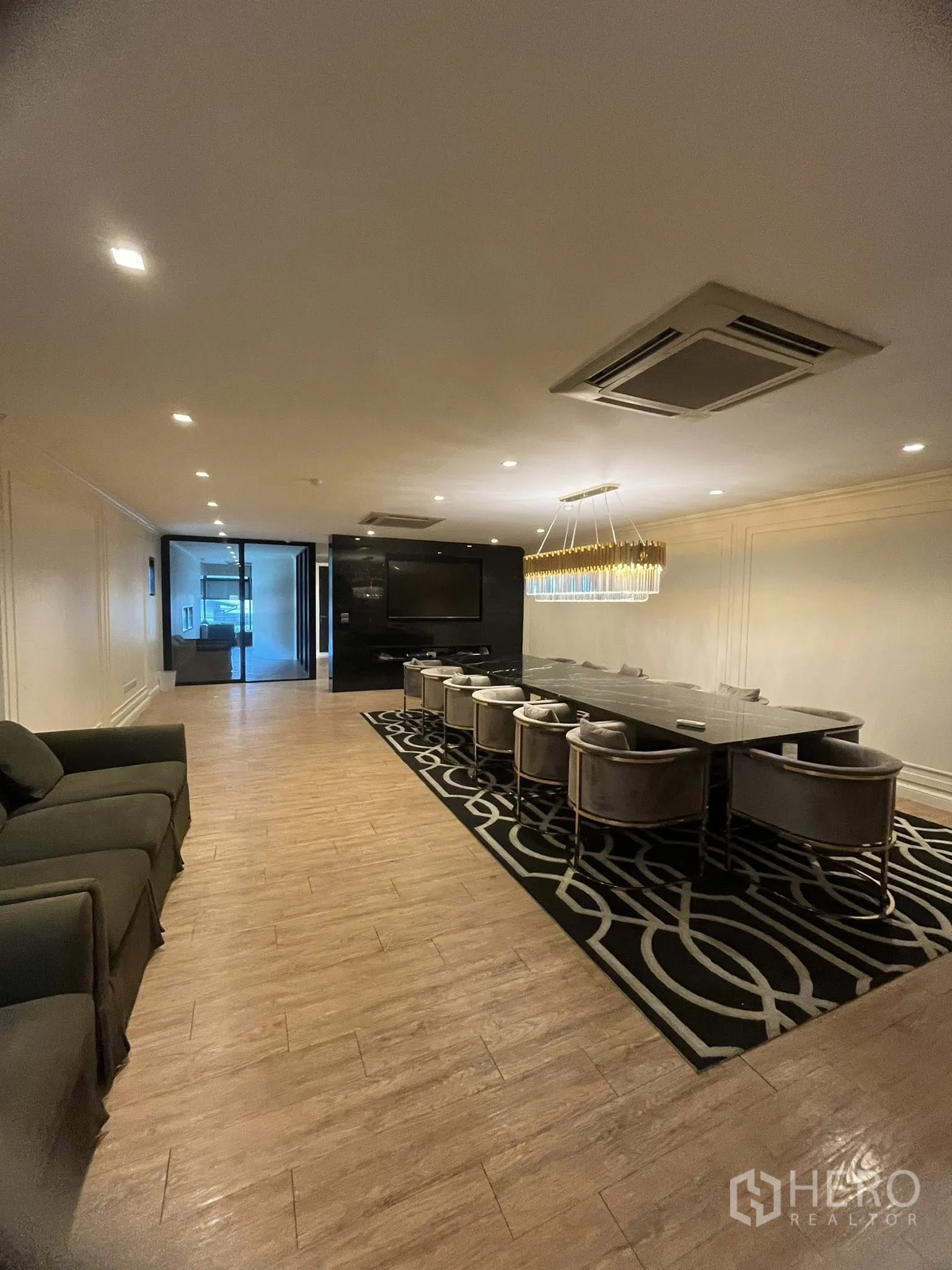 Home Office for rent in Watthana, Bangkok - Elegant meeting or dining room with a long table, chandelier, and sofa seating.