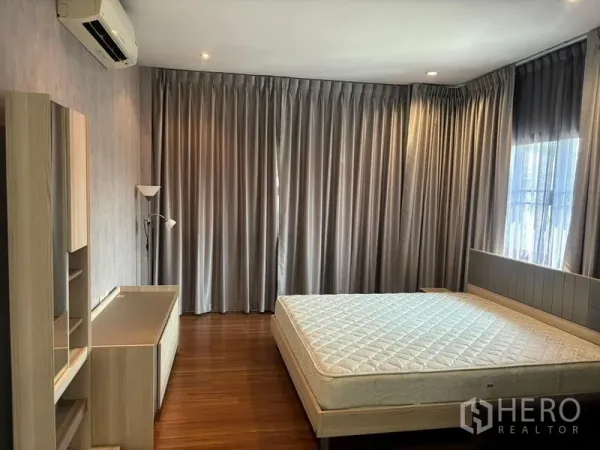 Detached House for rent in Bang Phli, Samut Prakan - Air-conditioned master bedroom with wood flooring, large bed and full drapes.