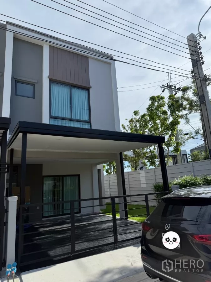 Townhouse for rent or sale in Bang Phli, Samut Prakan - Modern two-storey townhouse facade with covered carport and sliding gate.