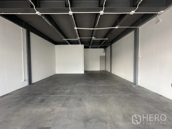 พื้นที่ขายปลีก ให้เช่า - พื้นที่ทรงลึกผนังสีขาว พื้นคอนกรีต พร้อมเดินท่อไฟและโคมไฟลอย