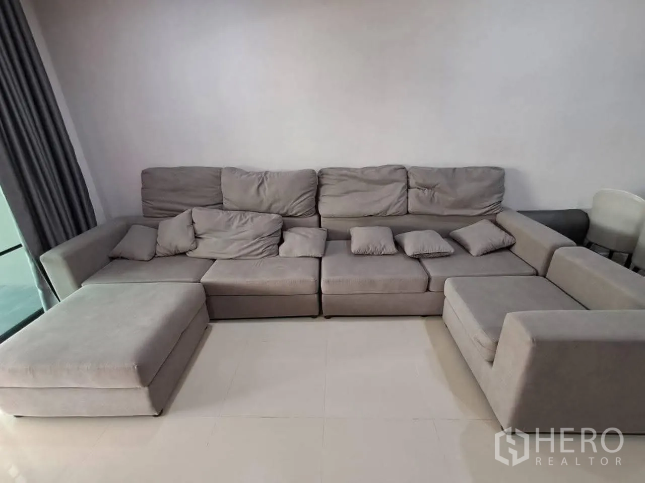 联排别墅 for rent in Bang Kapi, Bangkok - 客厅内的大型灰色L形沙发。