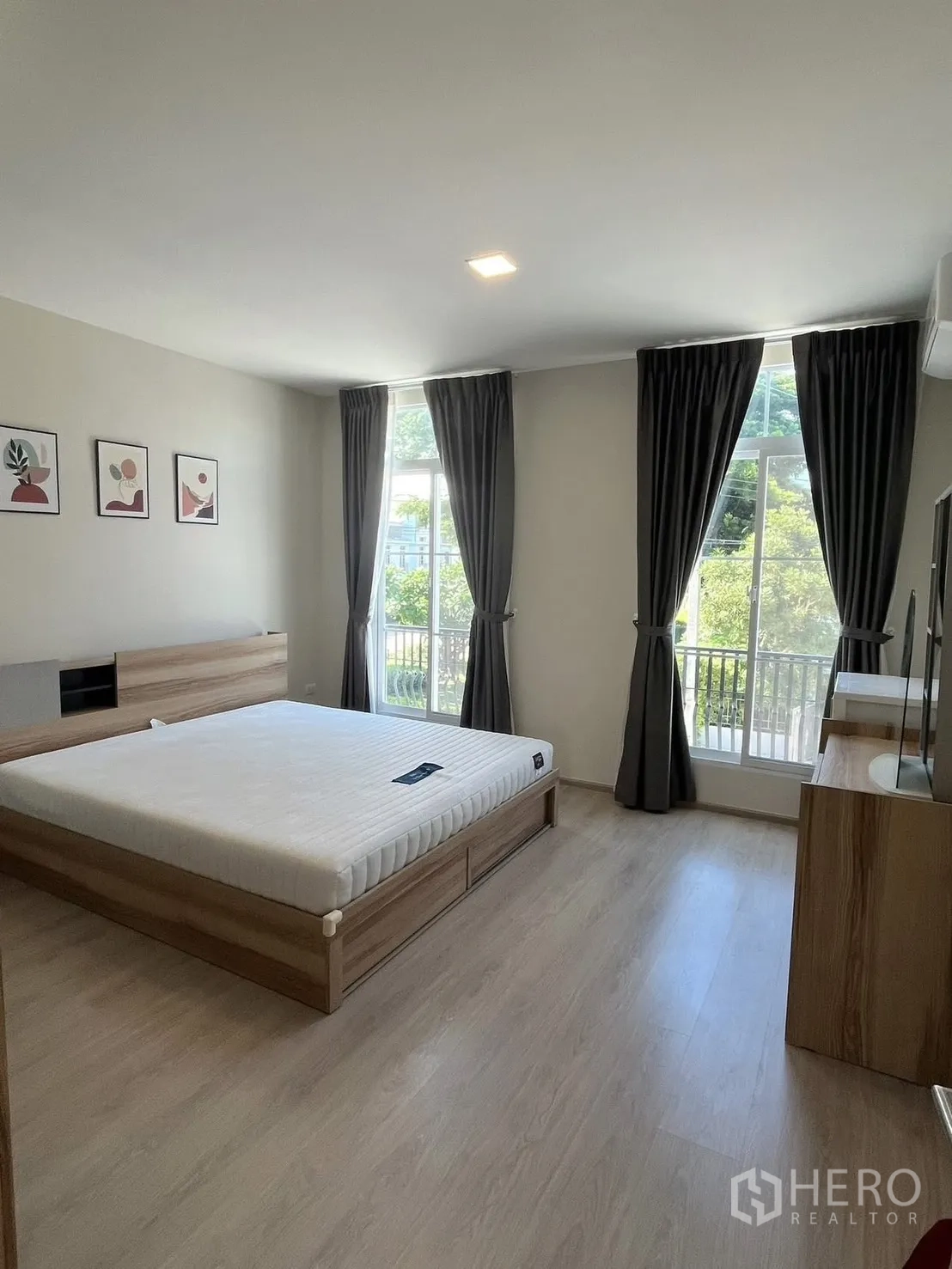 ทาวน์เฮาส์ for rent in Prawet, Bangkok - ห้องนอนหลักมีหน้าต่างบานใหญ่ ม่านทึบ และพื้นลายไม้.