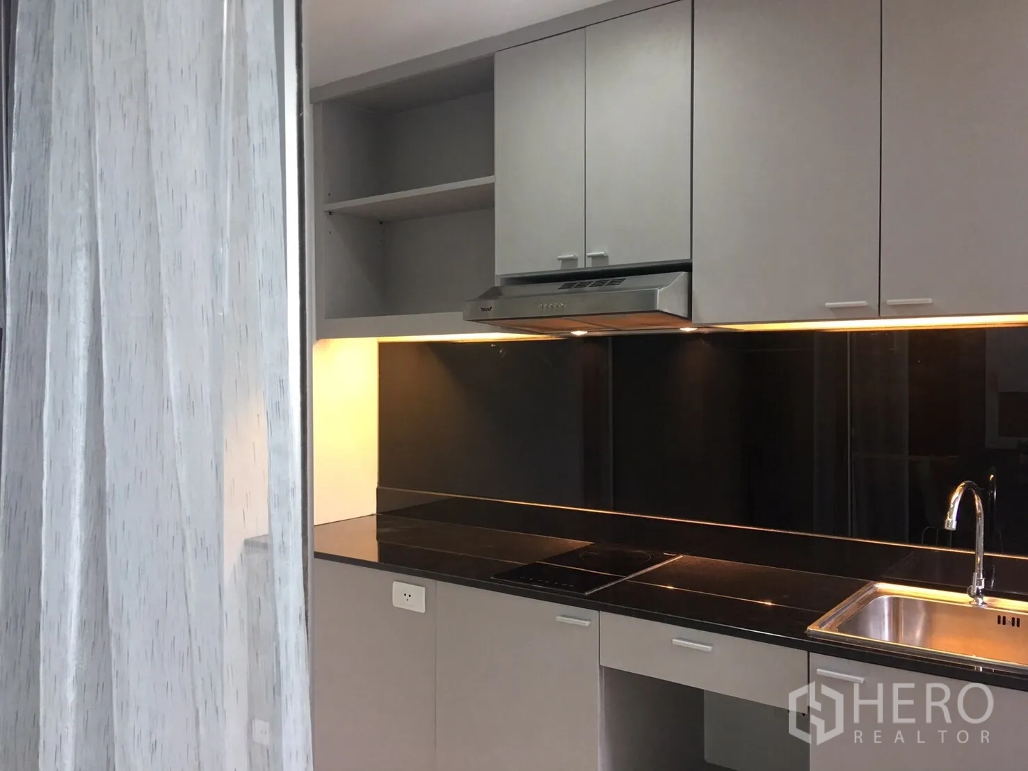 คอนโด ขายในPhra Khanong, Bangkok - ครัวสไตล์โมเดิร์น ตู้สีเทา แผงกันเปื้อนสีดำ เตาไฟฟ้า เครื่องดูดควัน และอ่างล้างจานสแตนเลส