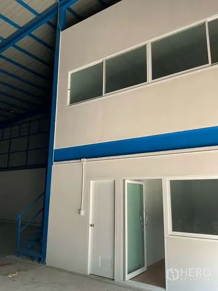 Warehouse for rent in Bang Bua Thong, Nonthaburi - Ground-floor office suite with sliding glass door and upper windows within the warehouse.