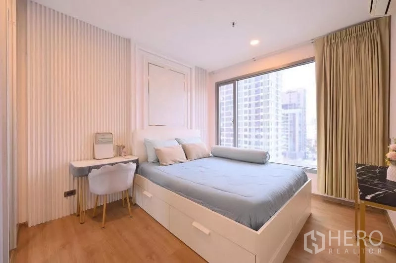 Condominium for rent in Watthana, Bangkok - Bedroom with queen bed, vanity desk and wide city‑view corner windows.