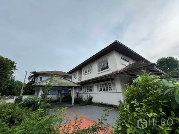 บ้าน ขายในPhra Khanong, Bangkok - สวนหน้าบ้านและทางเข้ารถสู่บ้านสองชั้น มีโรงจอดรถกันสาดและต้นไม้ใหญ่