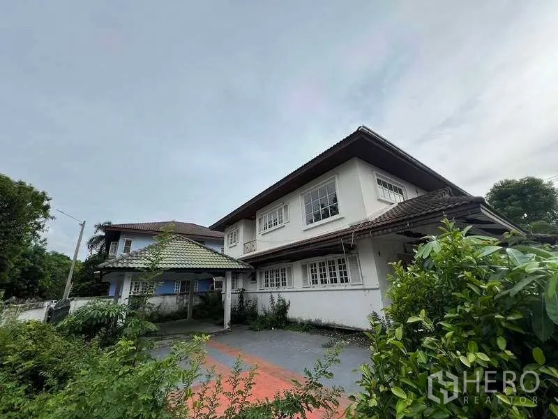 บ้าน ขายในPhra Khanong, Bangkok - สวนหน้าบ้านและทางเข้ารถสู่บ้านสองชั้น มีโรงจอดรถกันสาดและต้นไม้ใหญ่