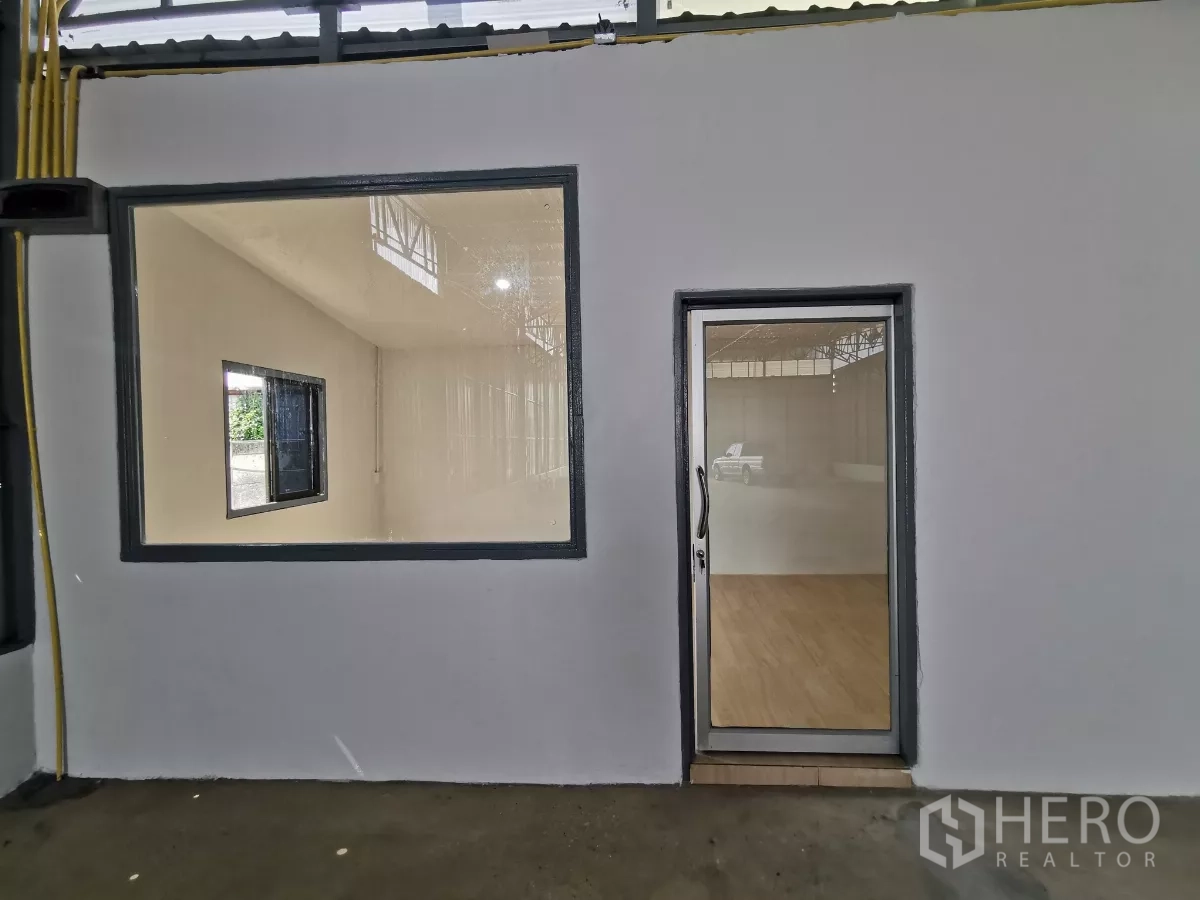 Warehouse for rent in Min Buri, Bangkok - Glass-door office with large viewing window inside the warehouse.
