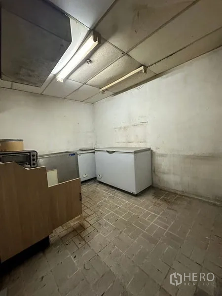 零售空间 出租在Yan Nawa, Bangkok - 储物间内放置多台卧式冰柜，荧光灯照明。