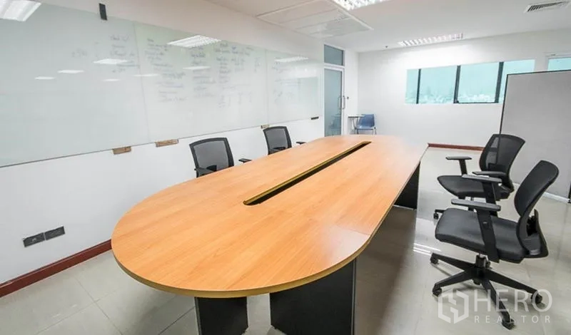 Office Space for rent in Huai Khwang, Bangkok - Conference room with long oval meeting table, ergonomic chairs and a whiteboard wall.