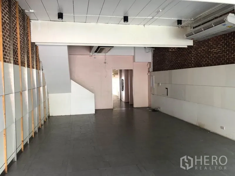 สำนักงานที่บ้าน ให้เช่าหรือขายในHuai Khwang, Bangkok - มุมมองพื้นที่ชั้นล่าง ผนังอิฐตกแต่ง พื้นกระเบื้อง และทางเดินไปส่วนหลังบ้าน