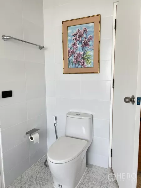 คอนโด ให้เช่าในKhlong Toei, Bangkok - ห้องน้ำสะอาดพร้อมโถสุขภัณฑ์ ราวแขวนผ้า และภาพดอกไม้กรอบทอง