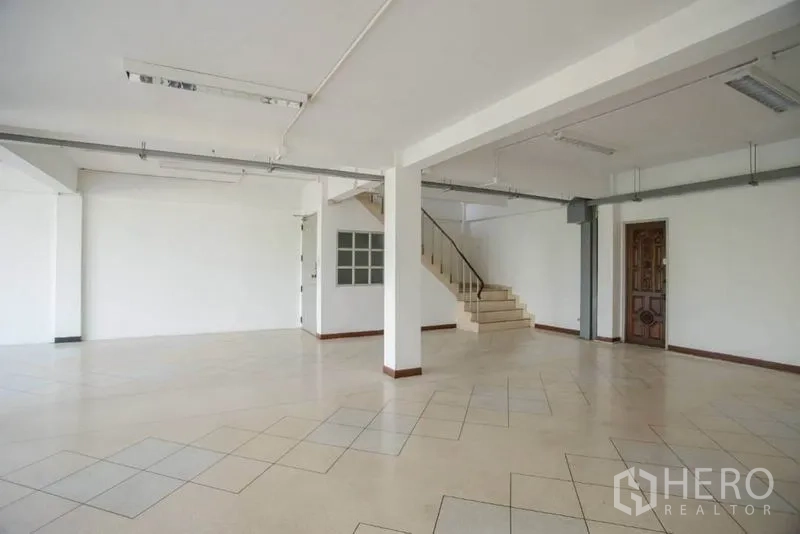 店屋 出租在Wang Thonglang, Bangkok - 大开间，侧边楼梯，白色墙面与木质入户门。