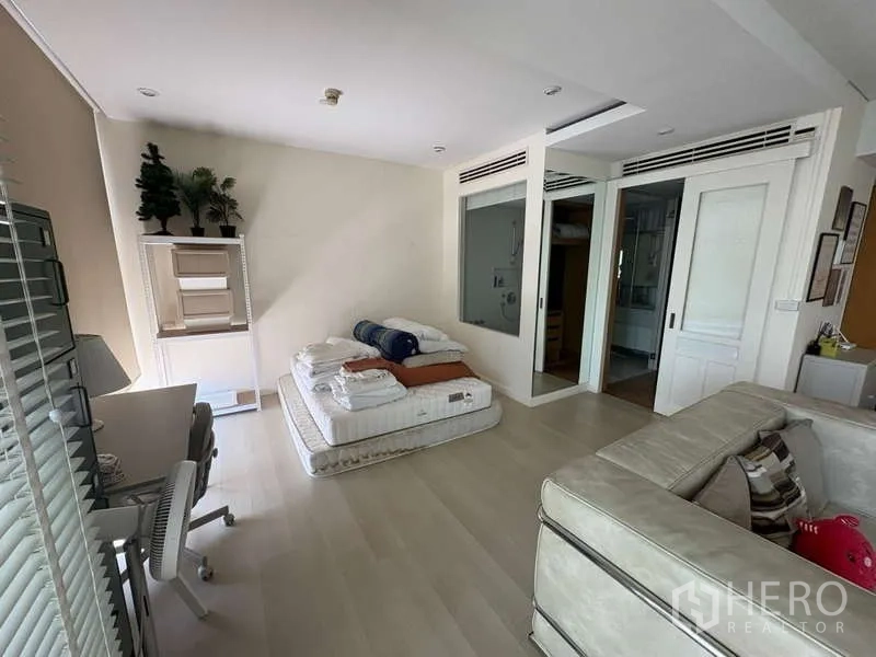 Condominium for rent - Bedroom zone with desk and sliding door to a bathroom with tub.