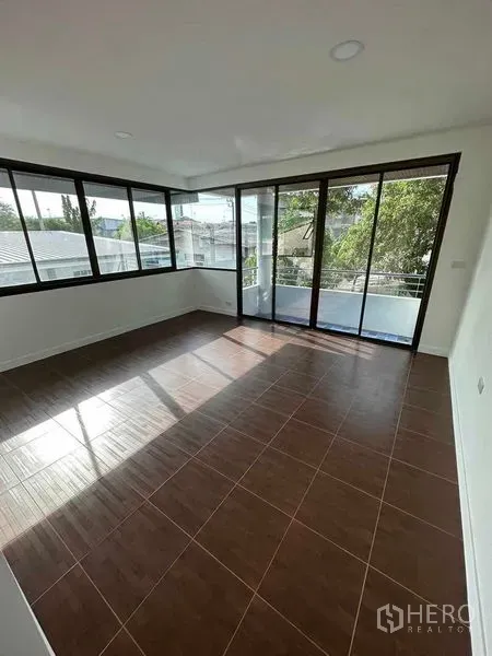 Home Office for sale - Bright corner room with brown tile floor, wraparound windows and sliding doors to a balcony.