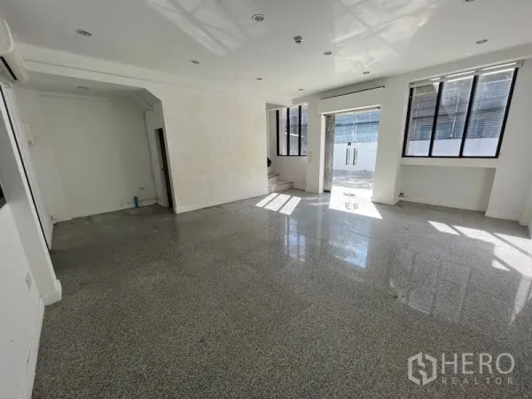 带办公室的家 出租在Bang Na, Bangkok - 采光充足的一层空间，磨石地面、嵌灯与大窗户。