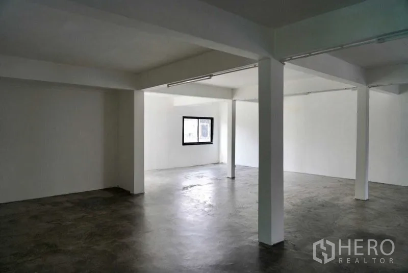 Office Space for sale in Khan Na Yao, Bangkok - Open space with exposed concrete flooring and white support columns, suitable for storage or back-of-house use.