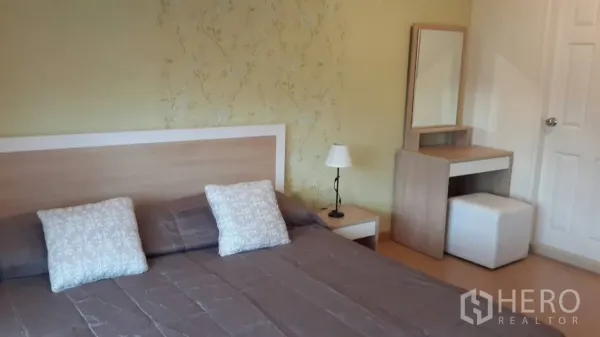 คอนโด ให้เช่าในWatthana, Bangkok - ห้องนอนหลักมีเตียงขนาดใหญ่ โต๊ะข้างเตียง โคมไฟ และโต๊ะเครื่องแป้ง ผนังลายอ่อน