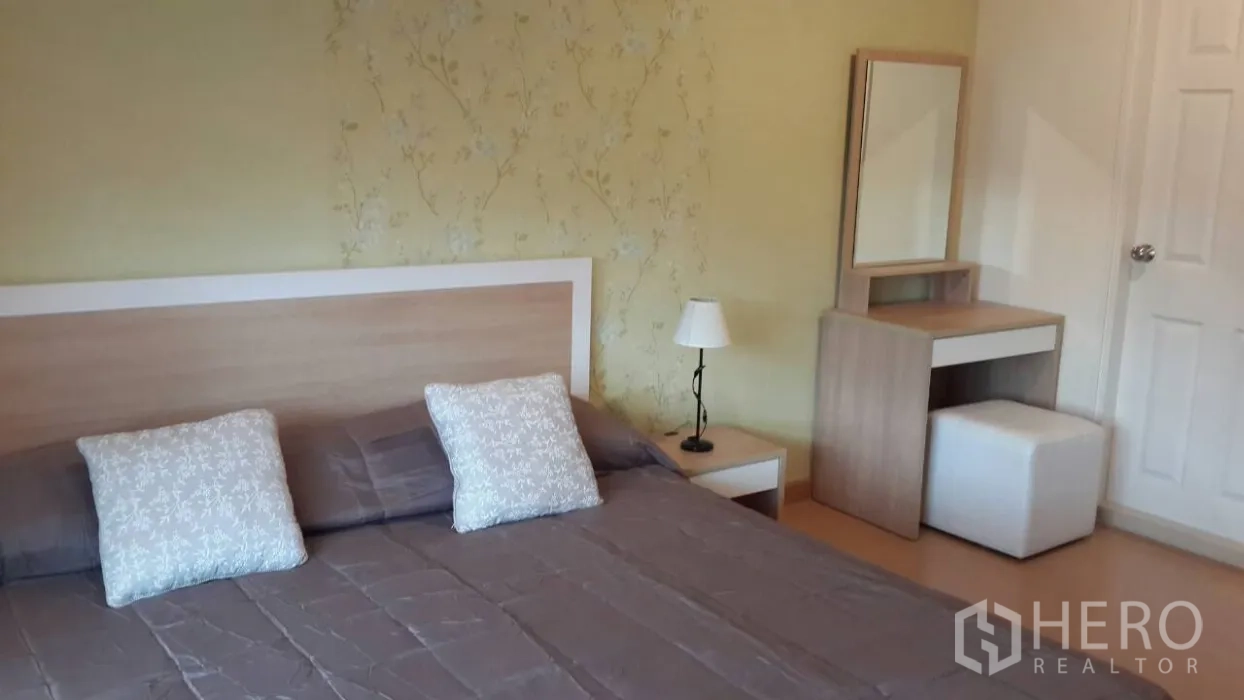 คอนโด ให้เช่าในWatthana, Bangkok - ห้องนอนหลักมีเตียงขนาดใหญ่ โต๊ะข้างเตียง โคมไฟ และโต๊ะเครื่องแป้ง ผนังลายอ่อน