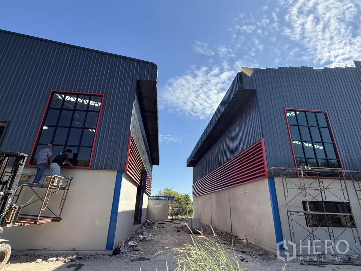 คลังสินค้า ให้เช่าในLam Luk Ka, Pathum Thani - อาคารโกดังคู่ขนาน หน้าต่างสูงและแผงระบายอากาศสีแดง