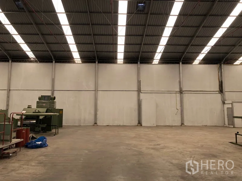 Warehouse for rent in Bang Bua Thong, Nonthaburi - Open storage area inside the warehouse with long skylights and high walls.