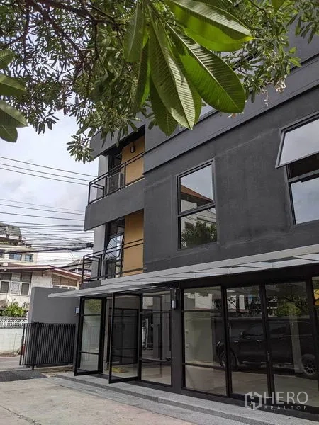 带办公室的家 出租或出售在Phaya Thai, Bangkok - 首层玻璃门厅入口，上方设阳台。