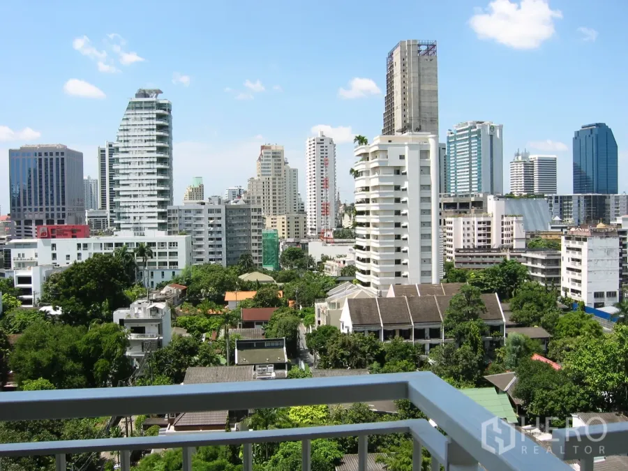 Condominium for rent or sale in Watthana, Bangkok - High-floor balcony view of the Watthana skyline and leafy neighborhoods under a clear Bangkok sky.