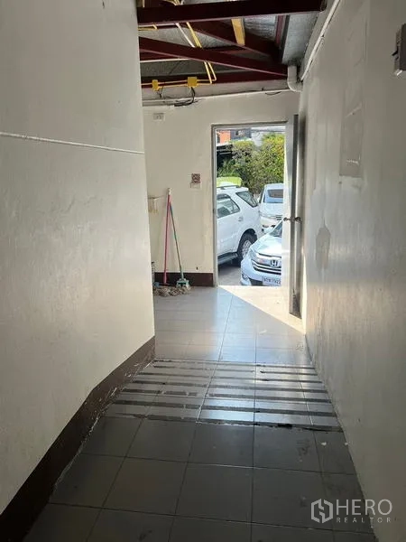 店屋 出租在Wang Thonglang, Bangkok - 瓷砖走道通向室外停车区，入口处自然采光充足。