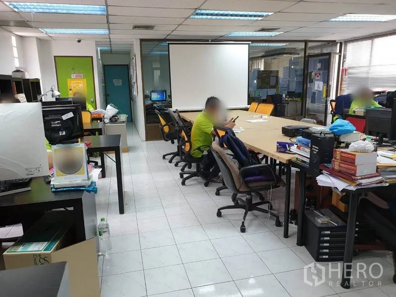 Office Space for rent in Bang Kapi, Bangkok - Collaborative office space with conference table, rolling chairs and bright ceiling lighting.