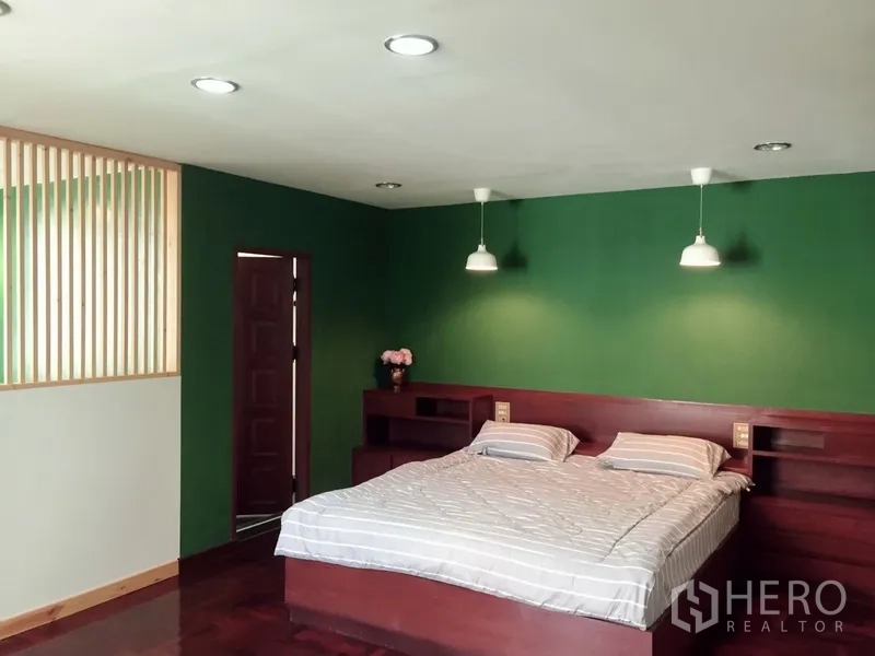 ทาวน์เฮาส์ ให้เช่าในWatthana, Bangkok - ห้องนอนกว้าง ผนังสีเขียว พร้อมหัวเตียงไม้บิลท์อิน